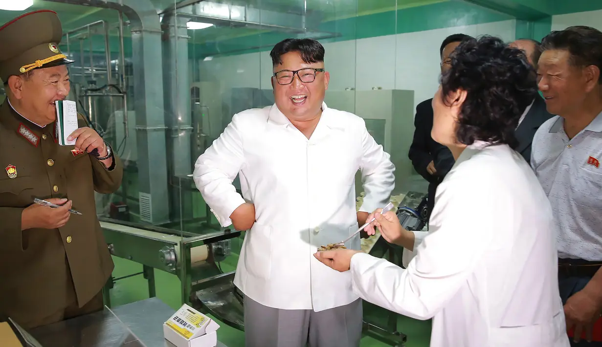 Tawa Pemimpin Korea Utara Kim Jong-un (tengah) saat mengunjungi Pabrik No. 525 di Korea Utara, Rabu (25/7). Pabrik No. 525 memproduksi makanan khusus atau ransum untuk tentara Korea Utara. (STRINGER/AFP/KCNA VIA KNS)