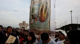 Peziarah membawa gambar Bunda dari Guadalupe saat mereka tiba di kawasan Basilika Guadalupe di Mexico City, Meksiko (11/12). Ritual ziarah ini dilakukan setiap tahunnya untuk menghormati Bunda dari Guadalupe. (Reuters/Henry Romero)