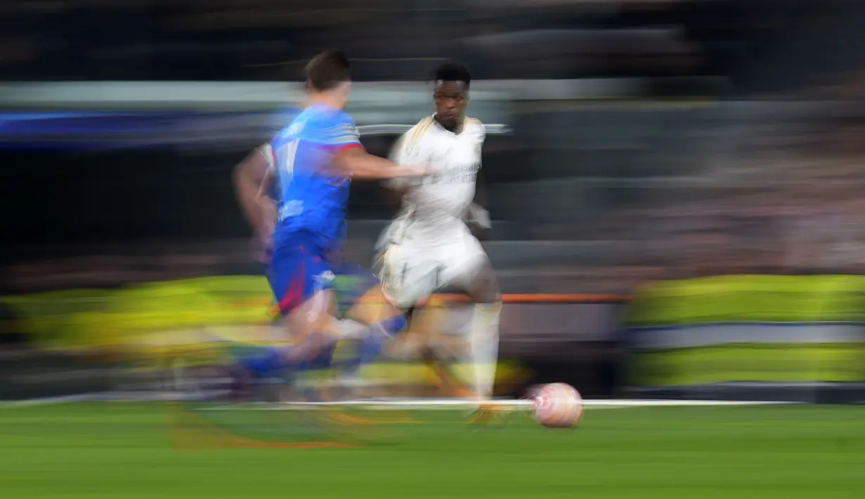 Pemain Real Madrid, Vinicius Jr menggiring bola dibayangi pemain RB Leipzig pada pada laga leg kedua 16 besar Liga Champions 2023/2024 di Santiago Bernabeu, Madrid, Spanyol, Kamis (07/03/2024) WIB. (AP Photo/Manu Fernandez)