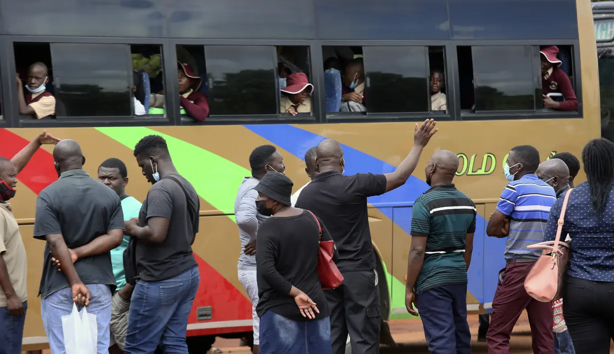 Orang tua mengantar anak-anak mereka pergi setelah mereka naik bus di Harare, Minggu (6/2/2022). Sekolah-sekolah di Zimbabwe dibuka kembali pada 7 Februari setelah penundaan selama berminggu-minggu dalam mengizinkan siswa kembali menyusul meningkatnya infeksi COVID-19 (AP Photo/Tsvangirayi Mukwazhi)