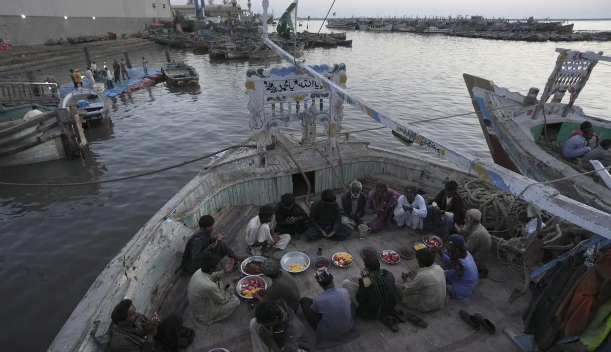 Nelayan berdoa sebelum berbuka puasa selama bulan suci Ramadhan, di sebuah pelabuhan, di Karachi, Pakistan, Senin, 27 Maret 2023. (AP Photo/Fareed Khan)