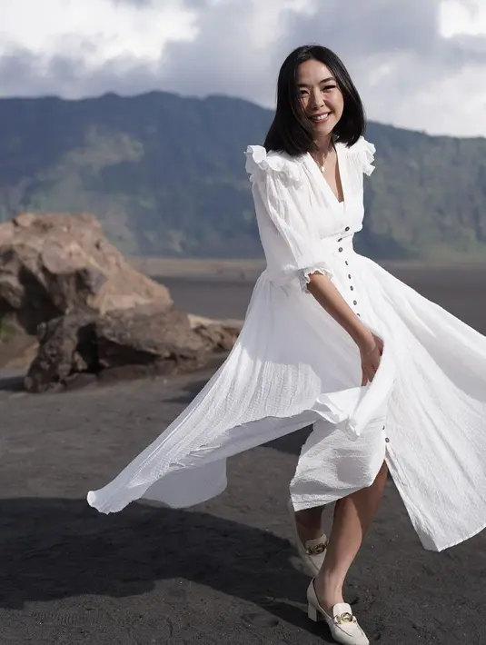Gisella Anastasia tersenyum saat menari dengan latar belakang keindahan Gunung Bromo untuk syuting video musik dari Setian Band. (Instagram/gisel_la)
