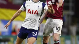 Pemain Tottenham Hotspur, Ben Davies berebut bola dengan pemain Burnley, Ashley Barnes pada pertandingan lanjutan Liga Inggris di stadion Turf Moor, Burnley, Inggris, Senin (26/10/2020). Tottenham menang tipis 1-0 atas Burnley. (Jason Cairnduff/Pool via AP)