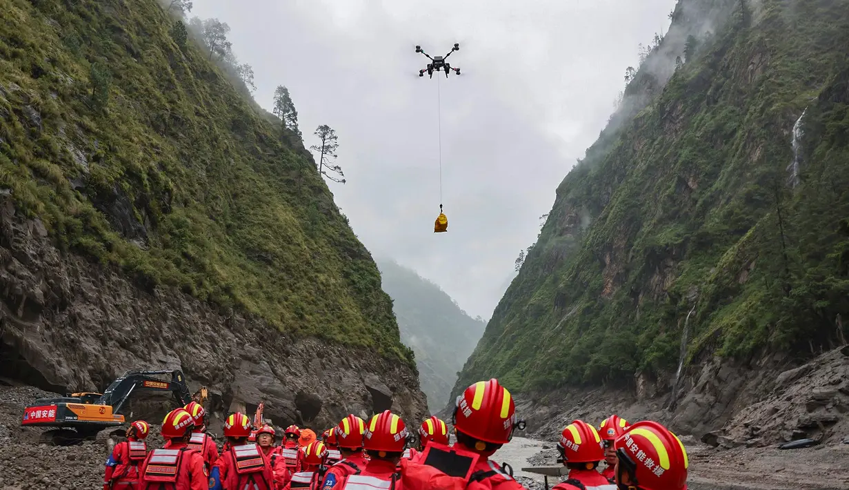 Sebuah drone membawa muatan melintasi udara saat operasi pencarian dan penyelamatan berlangsung di wilayah yang dilanda tanah longsor di Kabupaten Gyirong, Daerah Otonom Tibet, Tiongkok barat daya, Sabtu, 29 Agustus 2026. (Jiang Fan/Xinhua via AP)