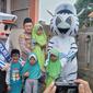 Kapolres Tasikmalaya AKBP Rimsyahtono berfoto bersama maskot tertib berlalu lintas dengan anak-anak usia 6-11 tahun peserta vaksinasi Covid-19. (Liputan6.com/Jayadi Supriadin)