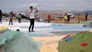 Turis mengunjungi Salvation Mountain, sebuah lereng bukti di Niland, California, Amerika Serikat. Salvation Mountain memiliki lebar 46 meter, dan panjang 15,2 meter ini tidak dihiasi pepohonan, melainkan tulisan dan gambar warna-warni dengan pesan cinta. (Robyn Beck/AFP)