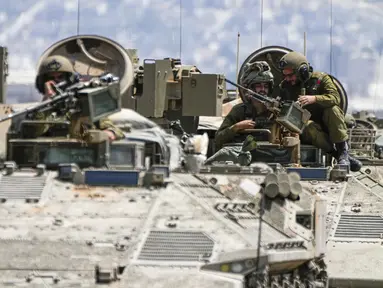 Tentara Israel mengusir APC dari Kota Jenin di Tepi Barat yang diduduki, selama serangan militer Israel pada kubu militan di kamp pengungsi Jenin, Selasa (4/7/2023). Pejabat kesehatan Palestina mengatakan sedikitnya 10 warga Palestina tewas dan puluhan lainnya terluka dalam operasi yang dimulai Senin. (AP Photo/Ariel Schalit)