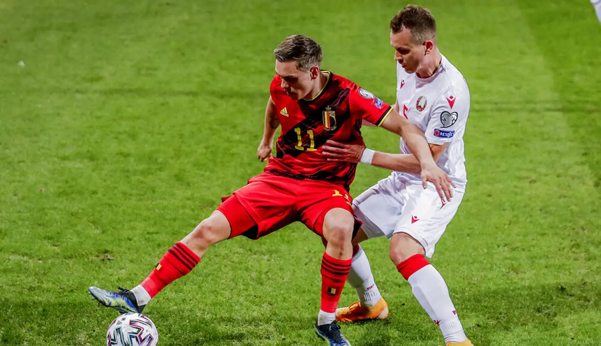 Pemain Belgia Leandro Trossard (kiri) bersaing memperebutkan bola dengan pemain Belarusia Denis Polyakov pada pertandingan Grup E kualifikasi Piala Dunia 2022 di Stadion King Power, Leuven, Belgia, Selasa (30/3/2021). Belgia menang 8-0. (AP Photo/Francisco Seco)