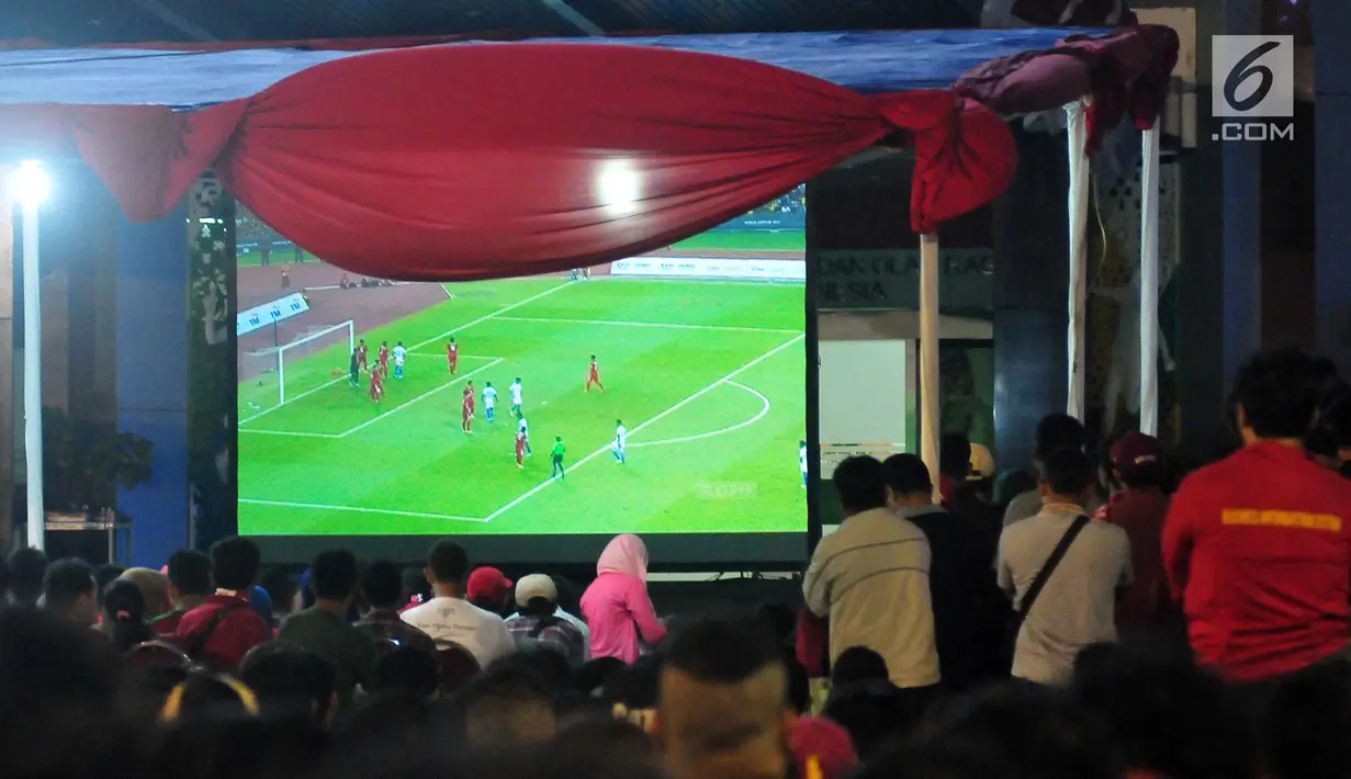 Sejumlah warga menonton pertandingan sepak bola Indonesia melawan Malaysia dalam pertandingan Sea Games 2017 di Area Kementerian Pemuda dan Olahraga, Jakarta, Sabtu (27/8). (Liputan6.com/Helmi Afandi)