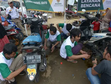 Relawan memperbaiki sepeda motor korban banjir pada layanan bengkel gratis Badan Amil Zakat Nasional (BAZNAS) di Kampung Pulo, Jakarta, Sabtu (4/1/2020). Layanan bengkel gratis ini banyak dimanfaatkan korban banjir untuk memperbaiki sepeda motornya yang sempat terendam. (merdeka.com/Imam Buhori)