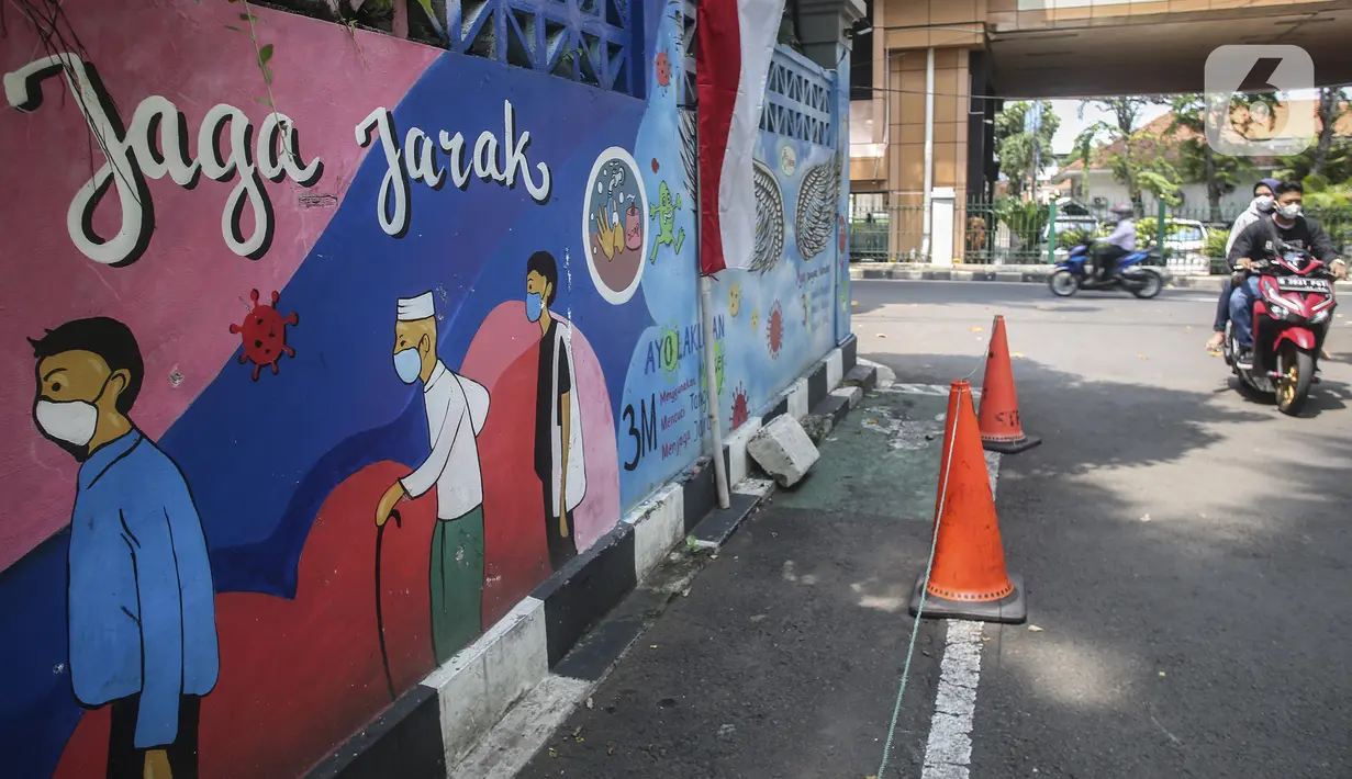 Warga yang mengenakan masker melintasi mural berisi imbauan terkait COVID-19 di Menteng, Jakarta, Kamis (7/10/2021). Menteri Kesehatan Budi Gunadi mengatakan perihal pandemi menjadi endemi dengan menyebutkan empat langkah yang dipersiapkan. (Liputan6.com/Johan Tallo)