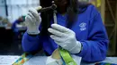 Pekerja memasangkan tali medali Olimpiade Rio 2016 di Casa da Moeda do Brasil (Brazilian Mint), Rio de Janeiro, Brasil, (28/6). Emas pada medali ini hanya sekitar 1,2 persen dan sebagain besar menggunakan plating. (REUTERS/Sergio Moraes)