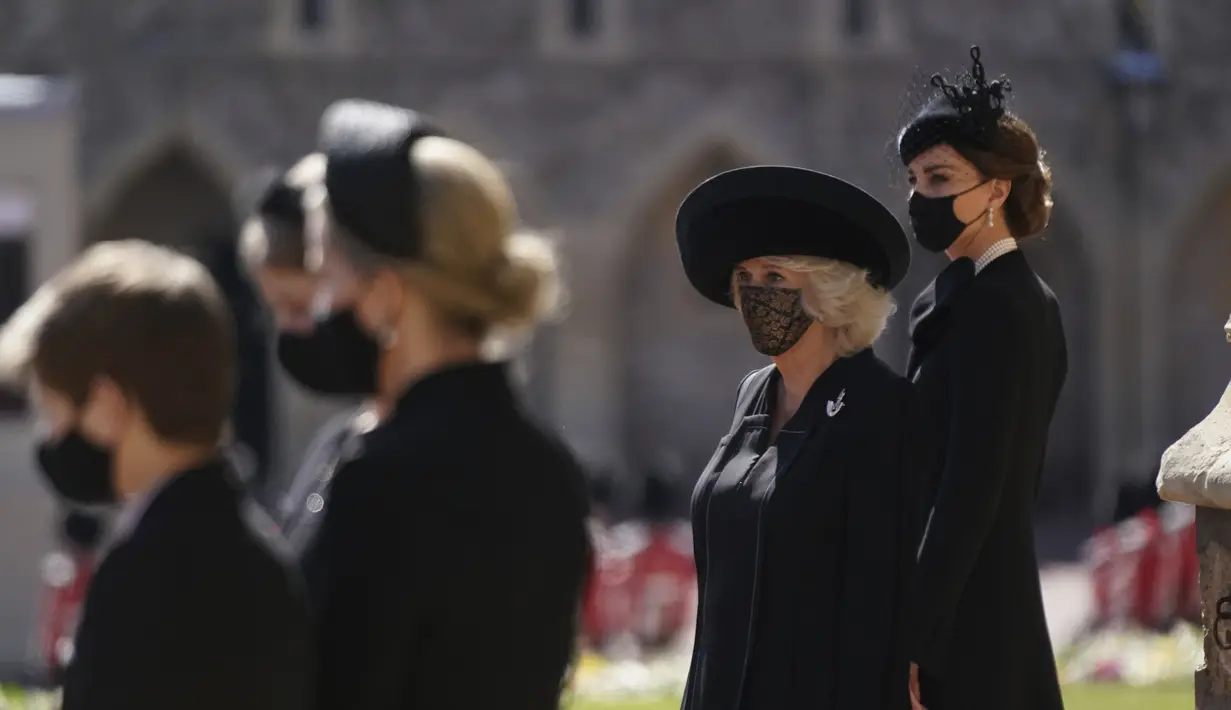 Kate Middletone, Duchess of Cambridge (kanan) berdiri menjelang pemakaman Pangeran Philip di kastil Windsor, Inggris (17/4/2021). Kate Middletone, Duchess of Cambridge tampil memesona dengan busana dan masker hitam. (Victoria Jones/Pool via AP)