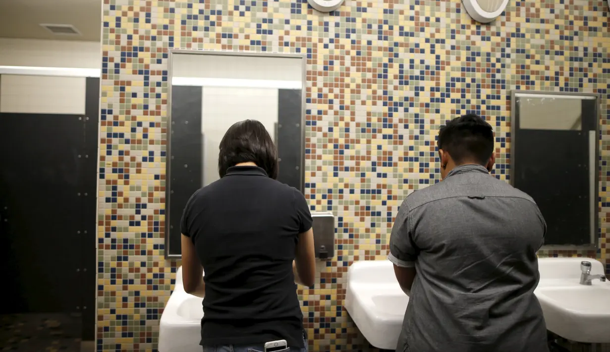 Dua siswa mencuci tangan mereka di toilet netral gender pertama di Santee High School, Los Angeles, California, AS, Senin (18/4). Toilet disediakan sebagai langkah mendukung dan menampung siswa transgender. (REUTERS/Lucy Nicholson)