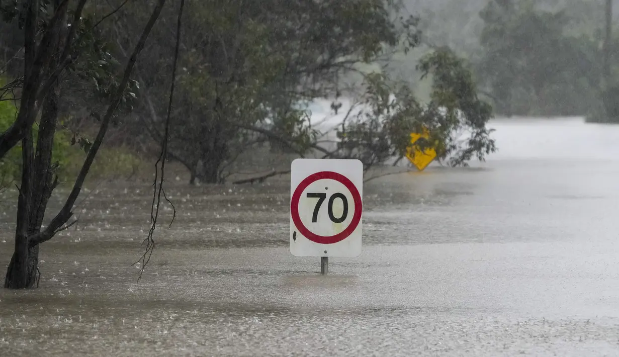 Rambu-rambu lalu lintas terendam di sepanjang jalan yang banjir di Londonderry di pinggiran Sydney, Australia, Senin (4/7/2022). Banjir kali ini merupakan yang terparah bagi kota terbesar di Australia tersebut selama 18 bulan terakhir. (AP Photo/Mark Baker)
