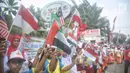 Siswa-siswi SD membawa bendera negara peserta Asian Games 2018 untuk menyambut Kirab Obor di kawasan Jati Padang, Pasar Minggu, Rabu (15/8). Mereka memenuhi jalanan untuk menyaksikan langsung Pawai Obor Asian Games 2018. (Liputan6.com/Faizal Fanani)