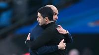 Pelatih Manchester City, Pep Guardiola memeluk pelatih Arsenal, Mikel Arteta, setelah laga final Carabao Cup di Stadion Wembley, Minggu (22/3/2026). (AFP/Glyn Kirk)