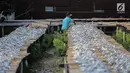 Pekerja menyelesaikan pengolahan ikan asin di kawasan Muara Angke, Jakarta, Kamis (4/7/2019). Hasil produksi ikan asin tersebut dipasarkan di wilayah Jakarta dan berbagai wilayah lainnya. (Liputan6.com/Faizal Fanani)