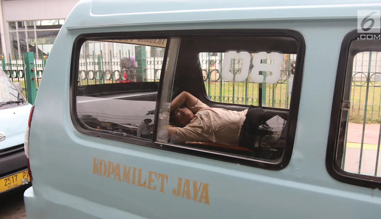 Seorang sopir angkot M08 trayek Tanah Abang-Kota tertidur di dalam kendaraannya di Jalan Jatibaru, Jakarta, Kamis (22/2). Para sopir terlihat sedang menunggu rekan sopir M03 dan M10 yang juga akan ikut berunjuk rasa. (Liputan6.com/Arya Manggala)