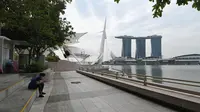 Seorang wanita duduk di Marina Bay di Singapura pada 6 Maret 2020. Tempat-tempat wisata utama di Singapura sepi dari turis di tengah epidemi virus corona COVID-19. (Xinhua/Then Chih Wey)