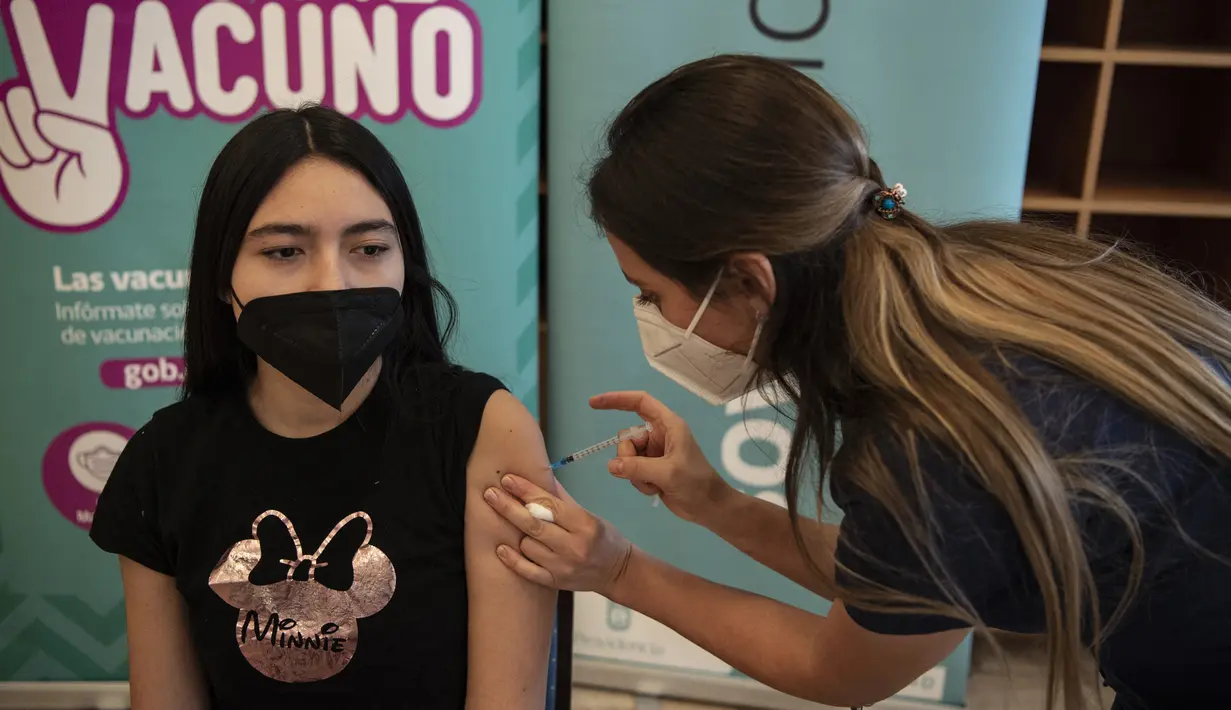 Petugas kesehatan menyuntikan vaksin COVID-19 Pfizer BioNTech kepada seorang anak di pusat vaksinasi di Santiago, Chile, Rabu (23/6/2021). Chile mulai memvaksinasi anak-anak dari usia 12 tahun, sebagai salah upaya untuk memutus rantai penyebaran infeksi virus Corona. (MARTIN BERNETTI/AFP)