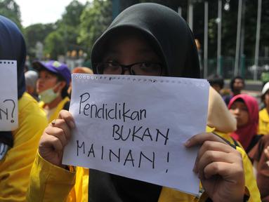 Mahasiswa membawa tulisan berisi kritikan saat aksi unjuk rasa memperingati Hardiknas, Jakarta, Senin (2/5). Mereka mendesak pemerintah untuk memberikan pendidikan gratis dan berkualitas serta dapat diakses seluruh rakyat. (Liputan6.com/Gempur M Surya)