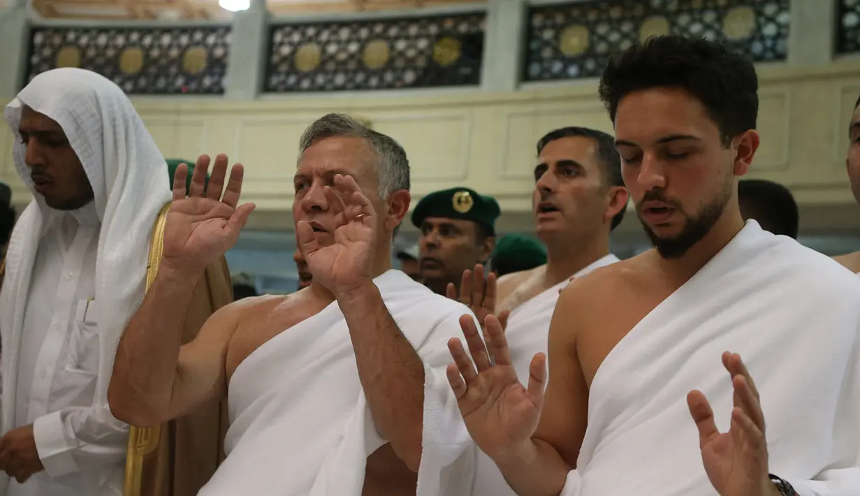 Raja Yordania, Abdullah II bin Al Hussein dan putranya Putra Mahkota Hussein bin Abdullah beribadah salat saat melakukan umrah pada bulan Ramdan di kota suci Mekkah (10/6). (AFP Photo/Jordanian Royal Palace/Yousef Allan)