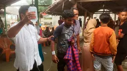 Petugas medis memberi perawatan kepada pengungsi Rohingya yang terdampar di Bireuen, Aceh, Jumat (20/4). Pengungsi yang diselamatkan terdiri atas 43 laki-laki, 25 perempuan, dan 8 anak-anak. (AP Photo / Zik Maulana)