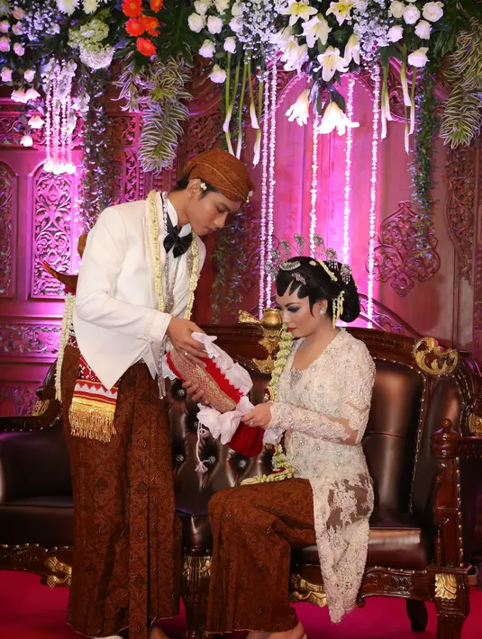 Gibran Rakabuming dan Selvi Ananda sedang melakukan prosesi kacar kucur. (Galih W. Satria/Bintang.com)
