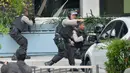 Polisi dari Densus Antiteror dan Gegana Polda Metro Jaya bersenjata laras panjang duntuk  mengambil posisi saat adu tembak dengan pelaku ledakan di pospol Sarinah, Jakarta, Kamis (14/1). (AFP PHOTO/Bay Ismoyo)