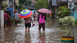 Warga berjalan melewati banjir di Perumahan Ciledug Indah 1 dan 2, Kota Tangerang, Banten, Sabtu (16/7/2022). Banjir yang merendam perumahan Ciledug Indah tersebut akibat meluapnya Kali Angke. (Liputan6.com/Angga Yuniar)