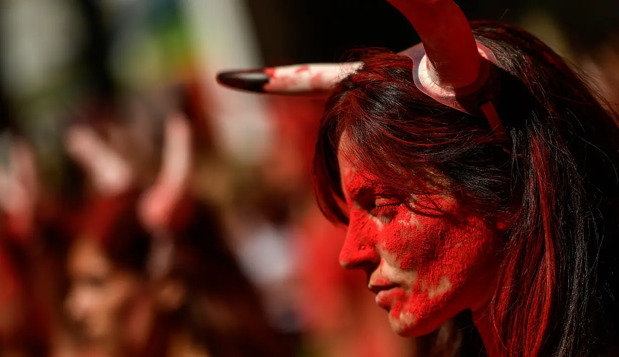 Seorang Akitivis mengenakan tanduk banteng saat unjuk rasa memprotes adu banteng dalam Festival San Fermin di Pamplona, Spanyol utara, (5/7). Aksi protes ini digelar sehari sebelum Festival San Fermin digelar. (AP Photo/Alvaro Barrientos)