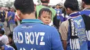 Seorang bobotoh menggedong anaknya saat hendak menonton Persib vs Bali United di Stadion Si Jalak Harupat, Bandung, Rabu (30/3/2016). Sang putra tampak anteng, tidak nakal alias Bad Boyz seperti tulisan di kaos sang ayah. (Bola.com/Nicklas Hanoatubun)