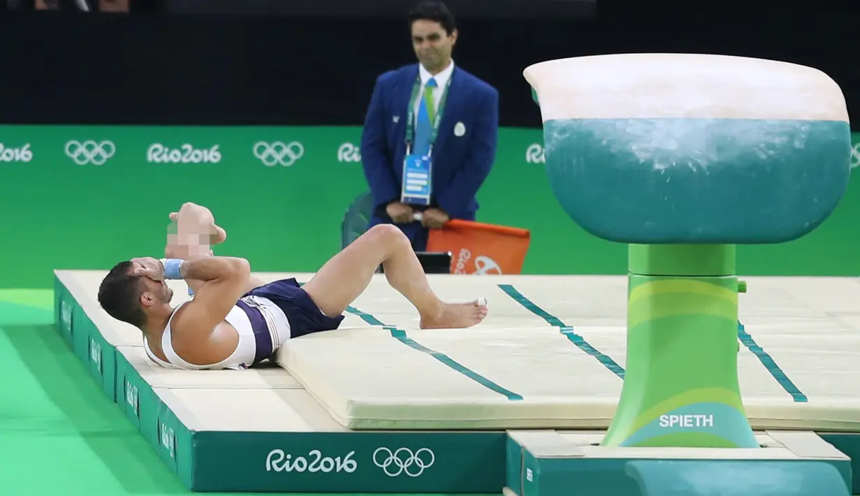 Atlet senam artistik Prancis Samir Ait Said tergeletak di lantai dengan posisi kaki patah pada babak kualifikasi Olimpiade Rio 2016 di Rio Olympic Arena, Brasil, Minggu (7/8). Samir gagal mendarat dan membuat kakinya patah. (REUTERS/Damir Sagolj)