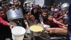Para pengungsi Palestina berkumpul untuk mengambil makanan yang sudah dimasak dalam sebuah pembagian makanan di Jabalia, Jalur Gaza utara, pada 19 Mei 2025. (Bashar TALEB/AFP)