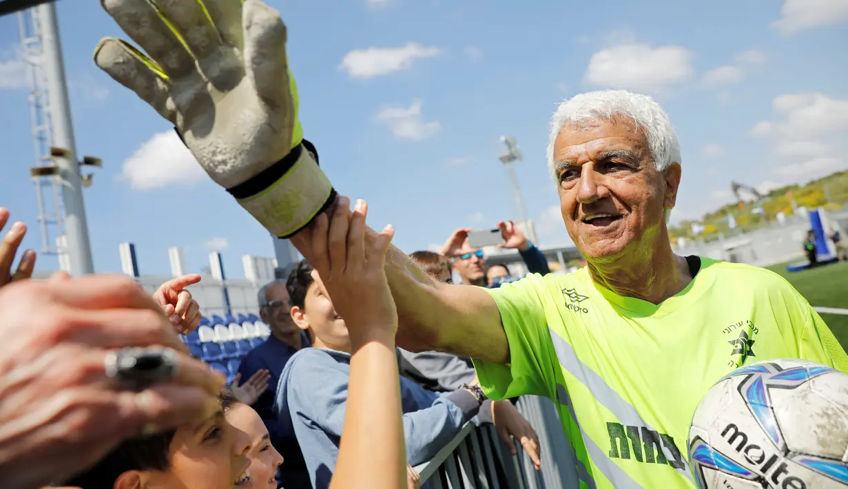 Isaak Hayik (73) merayakan penghargaan Guinness World Records usai pertandingan Liga Bet South A (kompetisi kasta keempat di Israel) di  Or Yehuda, 5 April 2019. Penjaga gawang klub Ironi Or Huda itu mencetak rekor sebagai pesepak bola tertua yang bermain pada laga profesional. (REUTERS/Amir Cohen)