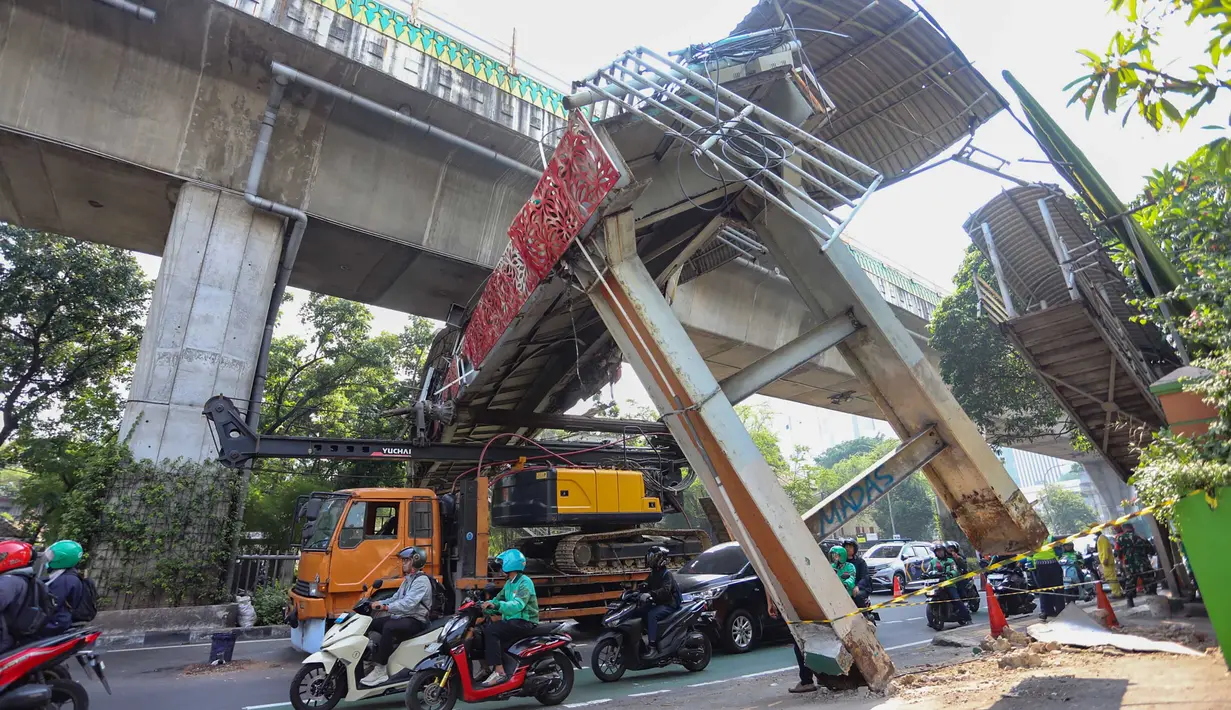 Sebuah truk  truk towing pengangkut alat berat (crane)  tersangkut dan merusak  jembatan penyeberangan orang (JPO) di Jalan Raya Kapten Tendean, Jakarta, Selasa (14/07/2026).
