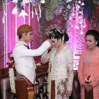 Selvi mencium tangan Gibran usai akad nikah (Galih W. Satria/Bintang.com)