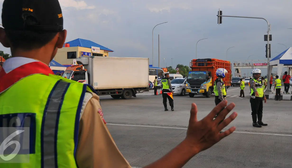 Anggota Pramuka ikut membantu Polisi mengatur lalu lintas di pertigaan pintu keluar tol Brebes, Jawa Tengah, Jumat (23/12). Selain polisi, sejumlah relawan dari anggota Pramuka ikut membantu kelancaran arus mudik Natal 2016. (Liputan6.com/Angga Yuniar)