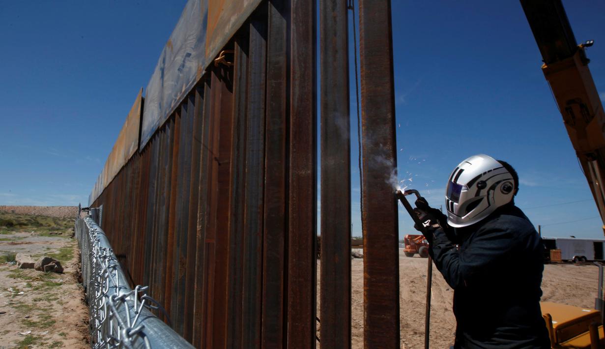 Seorang pekerja AS sedang mengelas bagian dari dinding perbatasan AS-Meksiko di Sunland Park, AS (09/9). AS dan Mexico dipisahkan oleh sekat teritorial yang menandakan wilayah kedaulatan masing-masing negara. (REUTERS/Jose Luis Gonzalez)