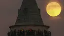 Bulan purnama terakhir tahun ini yang dikenal sebagai Cold Moon muncul di belakang menara Galata di Istanbul, Turki, Rabu (7/12/2022). Dijuluki Cold Moon karena Bulan purnama ini terbit pada salah satu malam “terpanjang” dalam setahun karena kedekatannya dengan titik balik Matahari musim dingin di Desember. (AP Photo/Emrah Gurel)