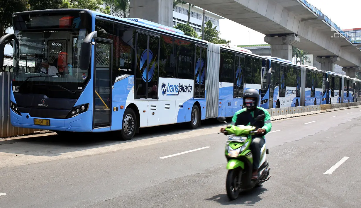 Pengendara motor melintas disamping deretan bus Transjakarta yang mogok kerja di kawasan Terminal Blok M, Jakarta, Senin (12/6). (Liputan6.com/Johan Tallo)