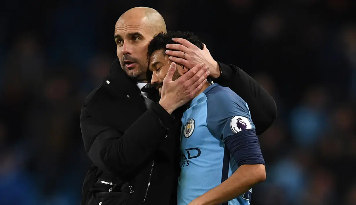 Pelatih Manchester City, Pep Guardiola memberikan dukungan kepada anak asuhnya Gael Clichy usai laga melawan Stoke City  pada lanjutan Premier League di Etihad Stadium, (8/3/2017). Manchester City bermain imbang 0-0.  (AFP/Paul Ellis)