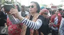Aktivis Ratna Sarumpaet mengabadikan gambar saat penertiban pemukiman penduduk di kawasan Rawajati, Jakarta, Kamis (1/9). Keberadaan Ratna di lokasi tersebut guna membantu mediasi warga yang rumahnya dieksekusi petugas. (Liputan6.com/Immanuel Antonius)