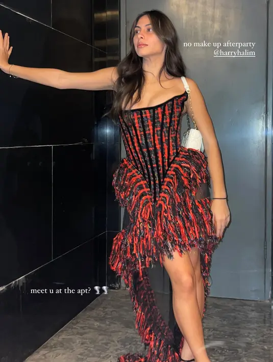 Ia kenakan korset tweed dress merah hitam dengan rok asimetris dan sling heels yang stylish [@valerieethomas]