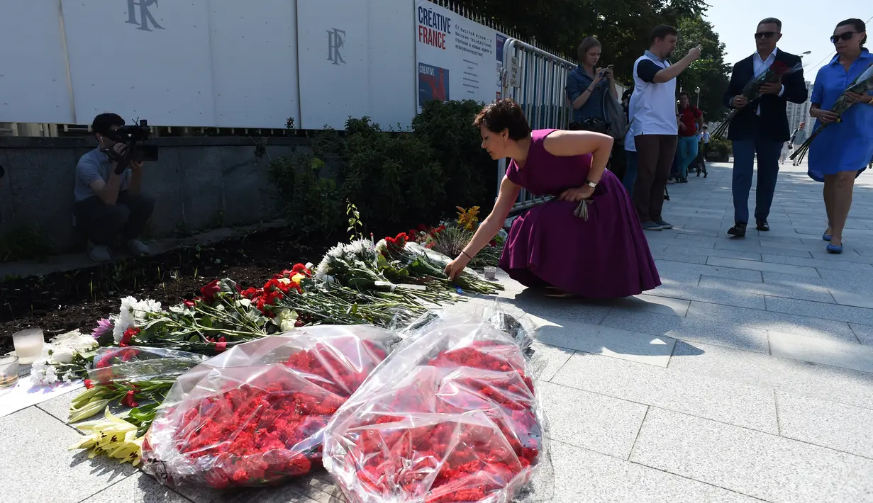 Sejumlah orang saat ingin meletakkan karangan bunga di luar Kedutaan Besar Prancis di Moskow, Rusia, (15/7). Sedikitnya 84 orang tewas dan ratusan lainnya luka akibat hantaman truk tersebut. (AFP PHOTO/Vasily Maximov)