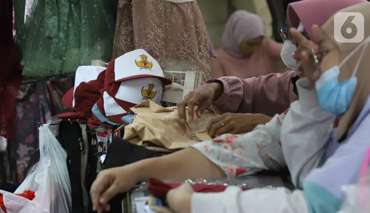 Pedagang melayani pembeli seragam sekolah di Pasar Kebayoran Lama, Jakarta, Jumat (8/7/2022). Menjelang dimulainya tahun ajaran baru, para orang tua disibukkan berbelanja baju seragam dan perlengkapan sekolah untuk anak mereka. (Liputan6.com/Angga Yuniar)