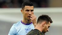 Pemain Riyadh All Star Cristiano Ronaldo diapit oleh pemain Paris Saint-Germain (PSG) Lionel Messi pada pertandingan sepak bola persahabatan di King Saud University Stadium, Riyadh, Arab Saudi, 19 Januari 2023. PSG mengalahkan Riyadh All Star dengan skor 5-4. (AP Photo/Hussein Malla)