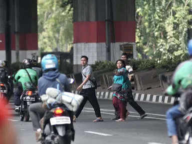 Pejalan kaki menyeberangi jalan di JPO di Prumpung, Jakarta, Selasa (18/9). Minimnya kesadaran warga menyeberangi jalan tanpa menggunakan JPO dapat membahayakan keselamatan serta menyebabkan kecelakaan.(merdeka.com/ Iqbal S. Nugroho)