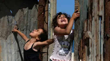Anak-anak bermain di rumah mereka saat Hari Nakba di kamp pengungsian Al-Shati, Jalur Gaza, Palestina, Rabu (15/5/2019). Rakyat Palestina memperingati 71 tahun Hari Nakba yang berarti 'malapetaka'. (MOHAMMED ABED/AFP)